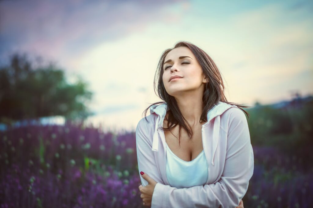 Woman relaxing in a field as part of her journey toward improved mental health