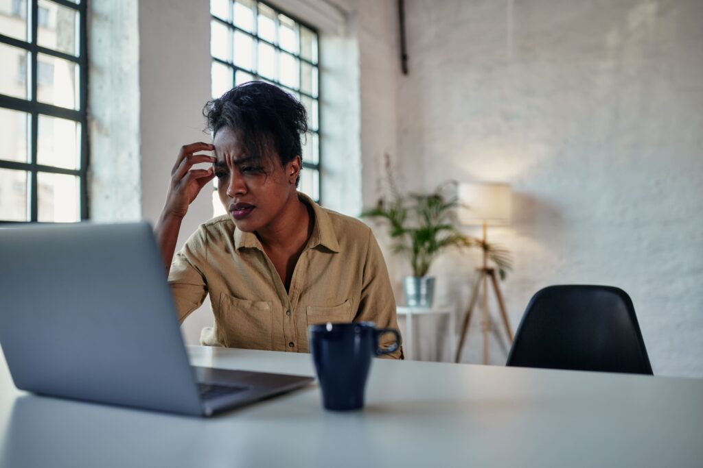 Stressed woman working from home at a laptop